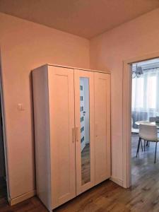 duża biała szafka w pokoju ze stołem w obiekcie Great Apart Imielin w Warszawie