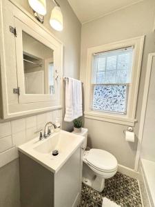 La salle de bains est pourvue d'un lavabo, de toilettes et d'une fenêtre. dans l'établissement Tandem House - 3 Bedroom SE Portland Gem!, à Portland