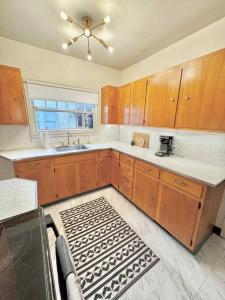 eine Küche mit Holzschränken, einem Waschbecken und einem Fenster in der Unterkunft Tandem House - 3 Bedroom SE Portland Gem! in Portland