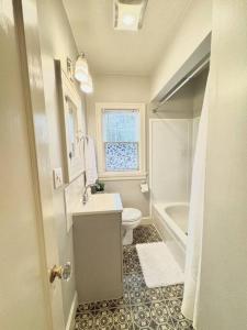 La salle de bains est pourvue d'un lavabo, de toilettes et d'une fenêtre. dans l'établissement Tandem House - 3 Bedroom SE Portland Gem!, à Portland