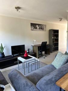 a living room with a couch and a table at Cozy Rondebosch Apartment in Cape Town