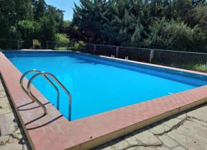 a large blue swimming pool with a metal hand rail at Alma Alquimia in Valle Hermoso
