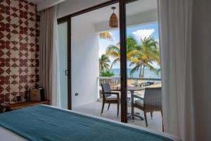 a bedroom with a bed and a view of the ocean at The Beachfront by The Fives Hotels in Playa del Carmen