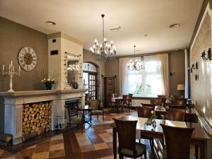 a restaurant with a fireplace and tables and chairs at Versant Hotel & Spa in Dzierżoniów