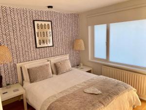 a bedroom with a bed with a sign on the wall at Seaview Cottage on the Island 