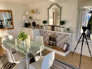a dining room with a glass table and a fireplace at Seaview Cottage on the Island 