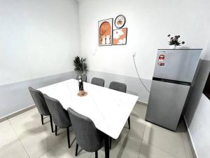 a dining room with a white table and a refrigerator at Pelangi Indah @ near JB AUSTIN #BBQ#KTV in Ulu Tiram