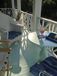 einen Tisch und Stühle auf einer Veranda mit einem Glas Wein in der Unterkunft House on the Gwynns Falls in Baltimore