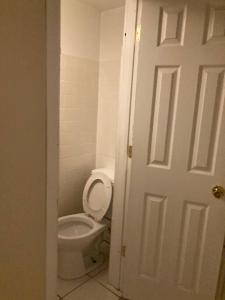 a white bathroom with a toilet and a door at Queen Bed w private ensuite bathroom in Lakeview - 3d in Chicago