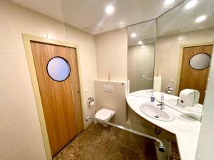 ein Badezimmer mit einem Waschbecken, einem WC und einem Spiegel in der Unterkunft Stylish home near city center in Wien