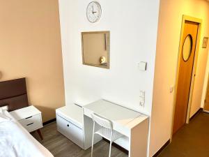 a bedroom with a desk and a clock on the wall at Stylish home near city center in Vienna