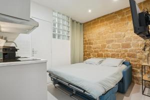 een bed in een keuken met een bakstenen muur bij Tiny Suite 12 D Paris’s heart! in Parijs