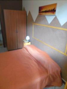 a bedroom with a bed with an orange blanket at Etna Residence Zafferana Etnea in Zafferana Etnea