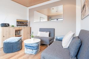 ein Wohnzimmer mit einem Sofa und einem Tisch in der Unterkunft Haus Schwanensee Seezauber in Bosau
