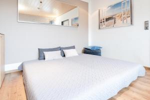 1 Schlafzimmer mit einem weißen Bett und 2 Fenstern in der Unterkunft Haus Schwanensee Seezauber in Bosau