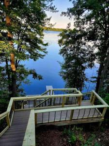 un puente de madera sobre un lago con árboles en Bliss on the Lake, en Wausau