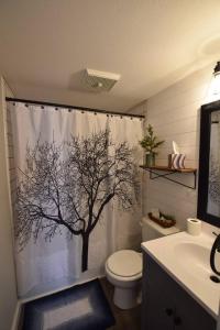 a bathroom with a shower curtain with a tree on it at Bliss on the Lake in Wausau