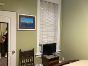 a room with a bed and a television and a window at Private room with full size bed in Lakeview - 3c in Chicago