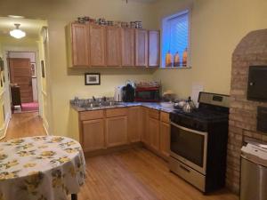 eine Küche mit Holzschränken und einem Tisch darin in der Unterkunft Private room with full size bed in Lakeview - 3c in Chicago