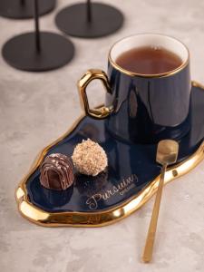 凱爾採的住宿－Gold Glass Jacuzzi Sauna Rynek-Parking，盘子里的一杯茶和一块蛋糕