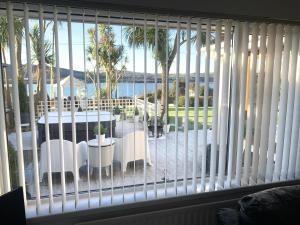 ein Fenster mit Blick auf eine Terrasse mit einem Tisch und Stühlen in der Unterkunft Seaview Cottage on the Island 