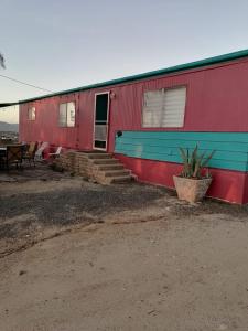 un edificio rojo y azul con escaleras y una mesa en Rancho Matalote en Valle de Guadalupe en Valle de Guadalupe