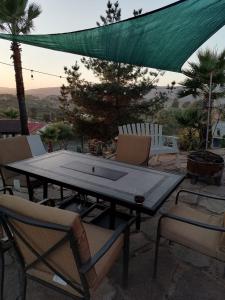 eine Tischtennisplatte und Stühle auf einer Terrasse in der Unterkunft Rancho Matalote en Valle de Guadalupe in Valle de Guadalupe