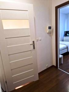 uma porta que leva a um quarto com uma cama em Great Apart Kabaty em Varsóvia