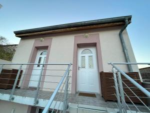 mały dom z białymi drzwiami i schodami w obiekcie Gaby, cosy & cocooning, idéal pour 2pers w mieście Villeurbanne