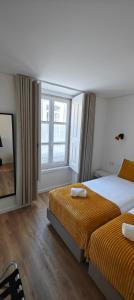 リスボンにあるCorreio Velho Suites IIのベッド2台と窓が備わるホテルルームです。