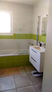 a bathroom with a bath tub and a sink at Chambre dans maison, près de la mer, de l'Espagne, des Montagnes in Pézilla-la-Rivière