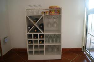 a shelf in a room with bottles and glasses at Villa Milena in Marzamemi