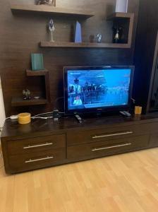 een flatscreen-tv bovenop een houten entertainmentcentrum bij Luxury Apartment Nasr City in Caïro