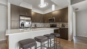 a kitchen with wooden cabinets and bar stools at Landing Modern Apartment with Amazing Amenities (ID8608X81) in Fort Myers Villas