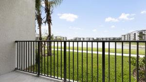 a balcony with a fence and palm trees at Landing Modern Apartment with Amazing Amenities (ID8608X81) in Fort Myers Villas