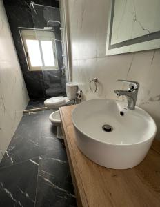 a bathroom with a sink and a toilet at Wave Beachfront Apartments in Durrës
