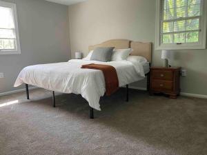 um quarto com uma cama com lençóis brancos e uma cómoda em 5 Bedrooms on a flat acre. Great water pressure! em Downingtown