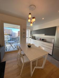 cocina con mesa blanca y sillas en una habitación en HZ+ Costantini en Pordenone