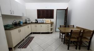 a kitchen with white cabinets and a table and chairs at Villa Alba in Natal