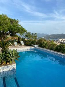 uma piscina azul com vista para o oceano em Casa Dos Arcos Bed and Breakfast em Arraial do Cabo
