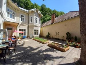 un cortile di una casa con un tavolo e delle sedie di Penzión Sandrik a Hodruša