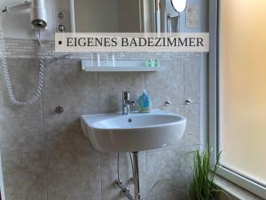 a bathroom with a sink and a mirror at Krabbe Doppelzimmer 4, am Elbe-Weser-Radweg mit Fahrradunterstellmöglichkeit, auch für E-Bikes, ideal für Kurzaufenthalte, Smart-TV 42 Zoll, kostenfreier Parkplatz, in Wremen