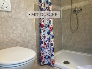 a bathroom with a toilet and a shower curtain at Krabbe Doppelzimmer 4, am Elbe-Weser-Radweg mit Fahrradunterstellmöglichkeit, auch für E-Bikes, ideal für Kurzaufenthalte, Smart-TV 42 Zoll, kostenfreier Parkplatz, in Wremen