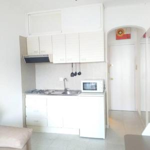 uma cozinha com armários brancos e um lavatório em Apartamento ALOHA BABY a 2 calles del Mar em Sant Salvador