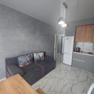 een woonkamer met een bank en een keuken bij Новобуд Зелена 261 Сихівська Пасічна Вашингтона in Lviv