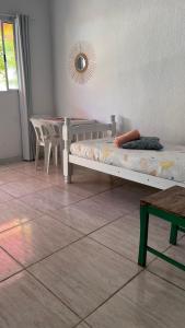 Pousada Suítes Sete Mares في غوارويا: غرفة نوم بسرير وطاولة في غرفة