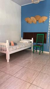 1 dormitorio con 1 cama y 1 silla verde en Pousada Suítes Sete Mares en Guarujá