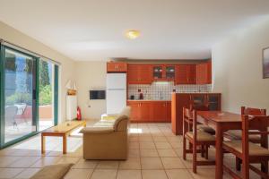 a kitchen and living room with a table and a dining room at Vivi's Apartments in Ayia Evfimia +28 photos