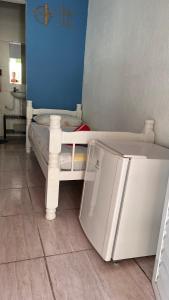 Pousada Suítes Sete Mares في غوارويا: سرير أطفال أبيض صغير في غرفة