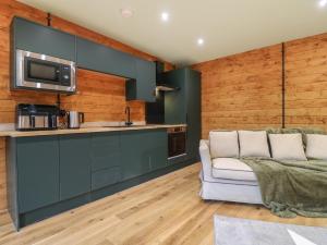 a living room with a couch and a kitchen at Otter's View in Oakham